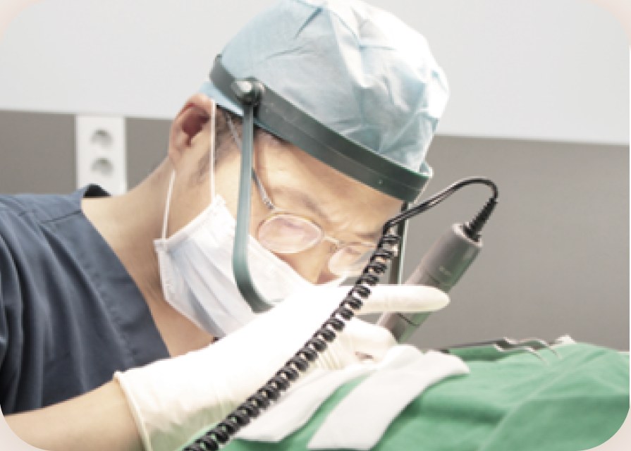 의료진이 확대경을 착용하고 모발을 이식하는 장면